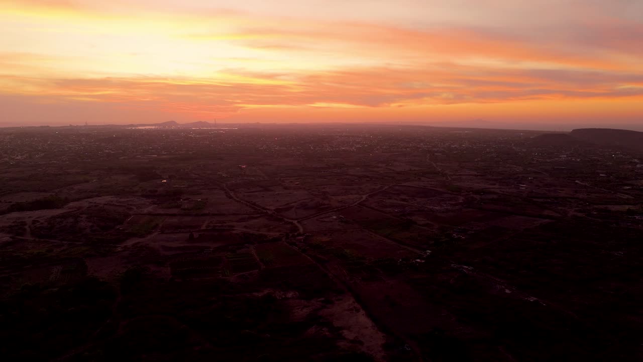 Dramatic sunset over the coast with the sky turning deep red and orange, soft waves rolling in the foreground