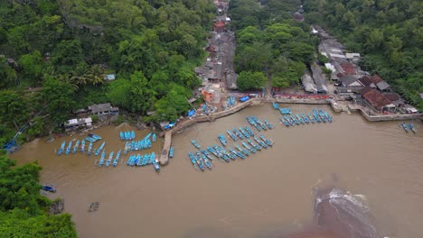 vista aérea de barcos de pescadores anclados en el puerto con agua de mar marrón