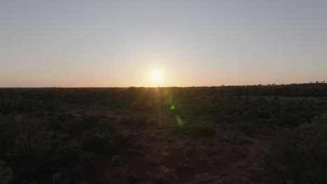 panning drone clip of bright sunrise over australian outback, with unique lens flares
