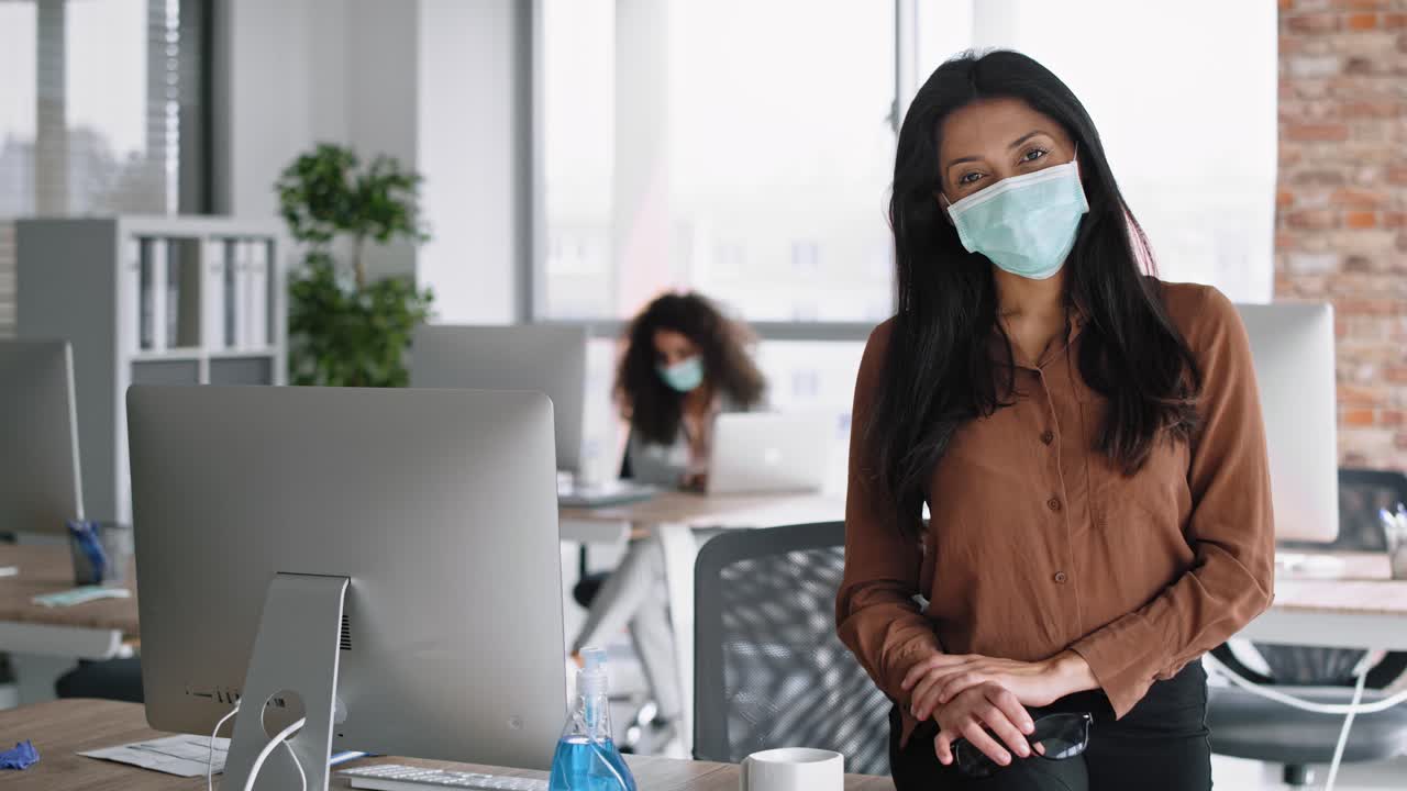 Video portrait of businesswoman sitting in protective face mask