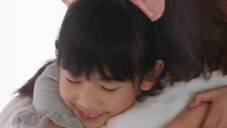 happy little asian girl hugging mother smiling embracing daughter enjoying motherly love cute child giving hug to mom showing affection at home family concept 4k footage