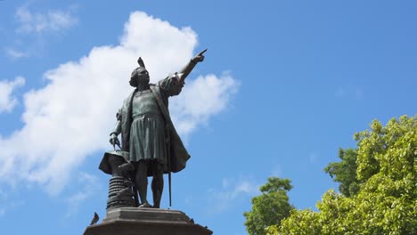 monument to christopher columbus against a blue sky in colonial city