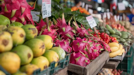 dragon fruit, mangoes, and bananas arranged on wooden crates in a bustling marketplace, creating a vibrant scene filled with fresh, colorful produce
