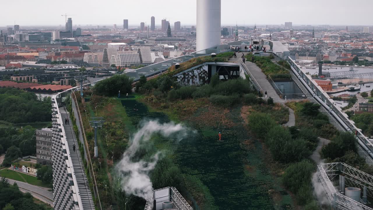 Descending view of family skiing down Copenhill rooftop slope, Copenhagen