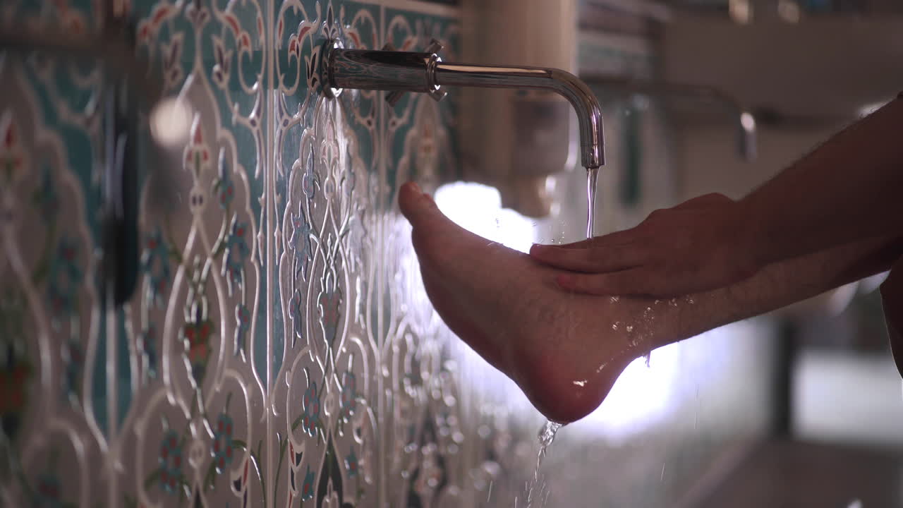 Muslim man washing his feet before entering to mosque
