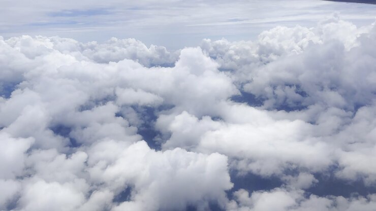Footage of white clouds and sky in motion, captured from an airplane. Perfect for travel, aerial views, and nature projects, showcasing serene skies and dynamic movement above the landscape.
