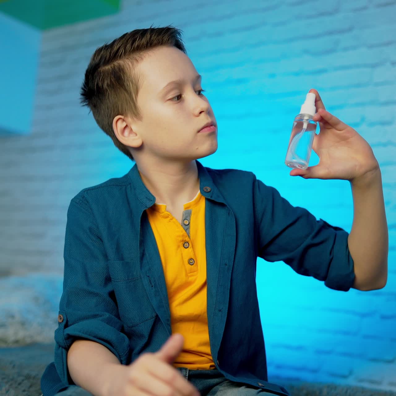 Boy using hand sanitizer alcohol spray rub for hands hygiene in home for preventive coronavirus spread epidemic prevention.