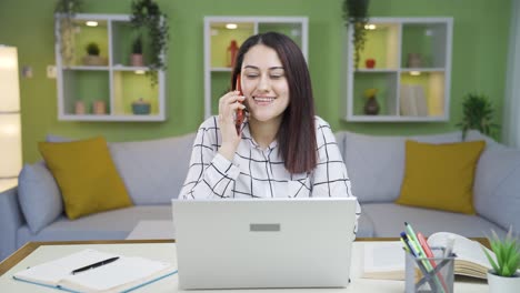 Young-business-woman-working-in-home-office-talking-on-the-phone.
