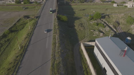 一架巴士和一辆汽车沿着铁路桥行驶的空中跟踪镜头