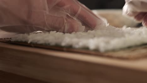 chef preparando rollos de sushi en la cocina