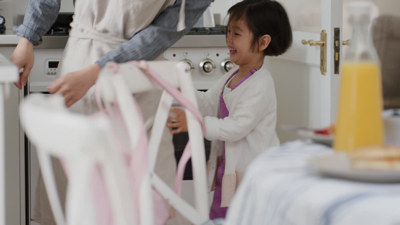 행복한 아시아 가족이 부 ⁇ 에서 춤을 추고 있습니다. 아버지는 딸과 함께 춤을 즐기고 있습니다. 어린 소녀는 웃고 있습니다. 집에서 흥미진진한 주말을 즐기고 있습니다. 4k 영상