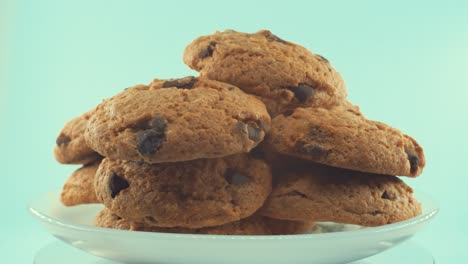 a close up shot of a white plate full of chocolate chip cookies, on a 360 rotating stand, studio lighting, slow motion, 4k video