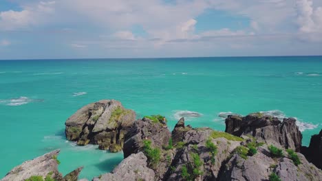 bermuda drone shot de la bahía de la herradura con gente escalando las formaciones rocosas y una vista al mar