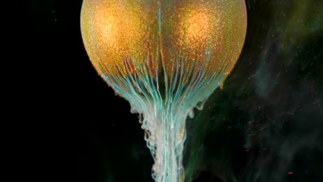 la pintura de brillo dorado fluye lentamente de la pelota