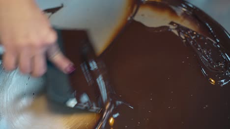 confectioner mixes chocolate glaze using pastry scraper