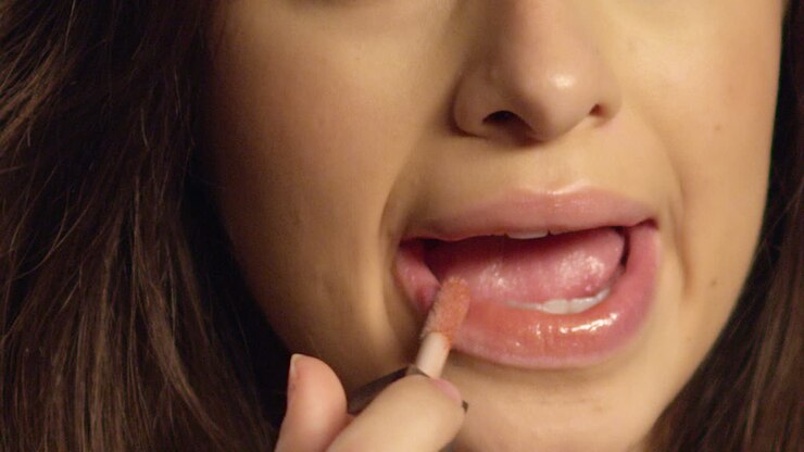 Extrem-Nahaufnahme: Junge Frau trägt Lipgloss auf
