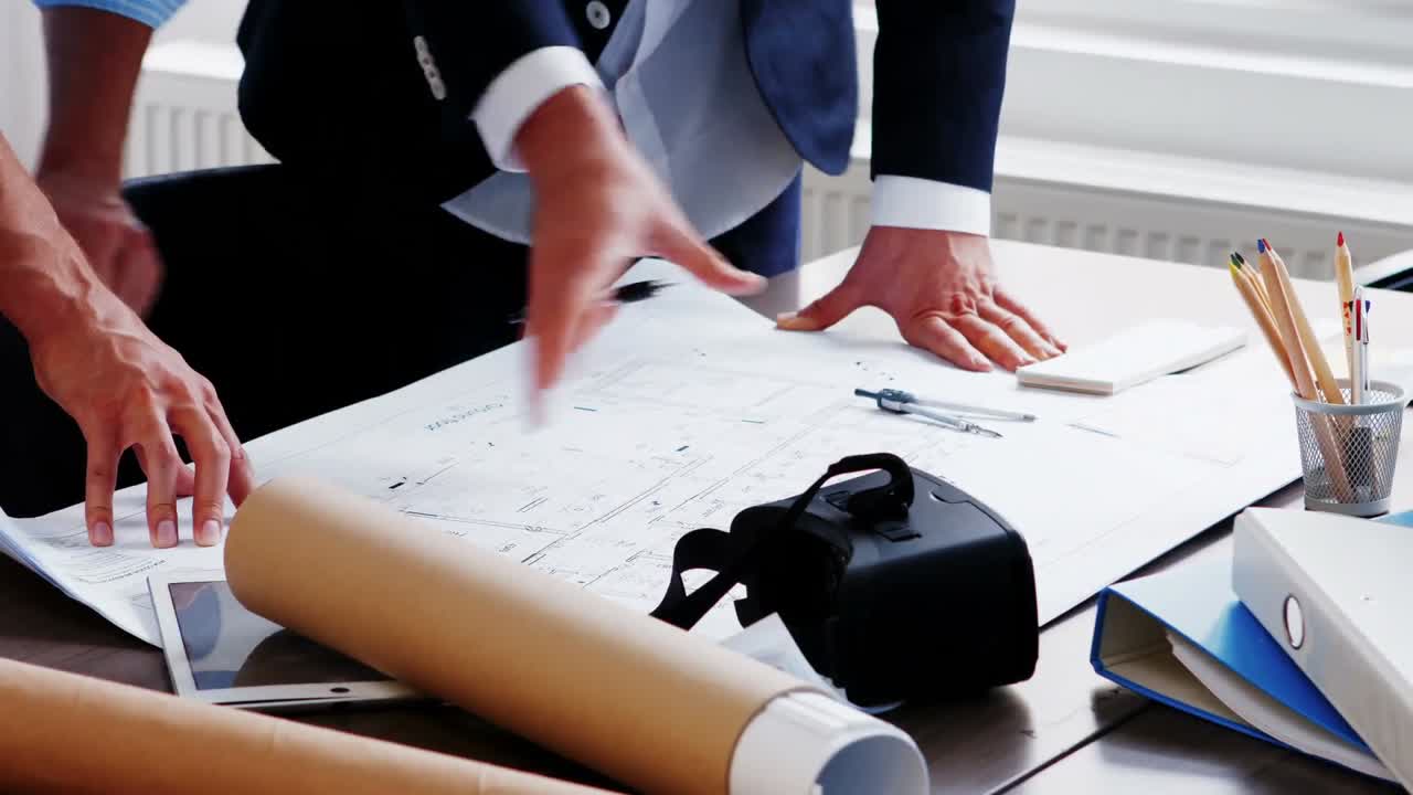 비즈니스 동료들이 청사진에 대해 논의하고 있습니다.