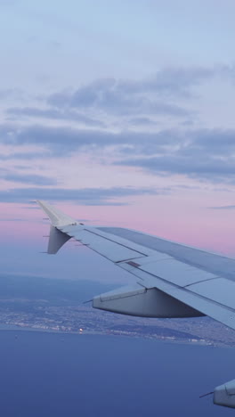 vista desde una ventana de avión del cielo al amanecer con el ala del avión en el tiro en vertical