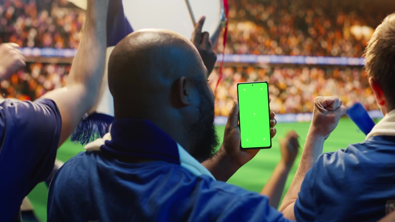 Primo piano di uno smartphone mockup utilizzato da un uomo sugli spalti di uno stadio di calcio