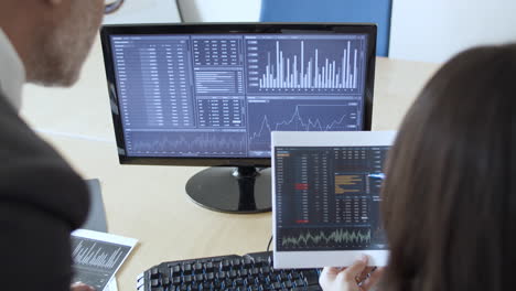 grey haired mature expert explaining financial charts to business worker