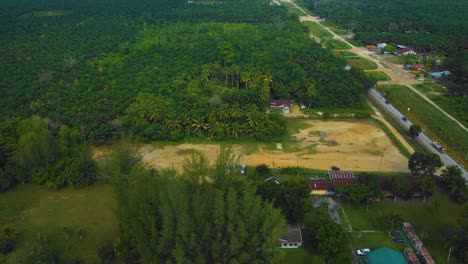 Cinematic-Drone-Footage-of-Palm-Oil-Mill-Effluent-residential-consists-of-buildings,-homes,-main-road-and-infrastructure-surrounded-by-palm-oil-trees-deforestation-located-in-Indonesia-in-full-HD