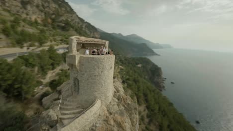 FPV-drone-forward-moving-shot-over-Ricardo-Roca-Viewpoint-over-steep-cliff-overseeing-deep-blue-sea-in-Illes-Balears,-Spain-on-a-sunny-day