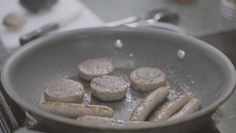 A-slowed-down-shot-of-sausage-sizzling-in-a-frying-pan