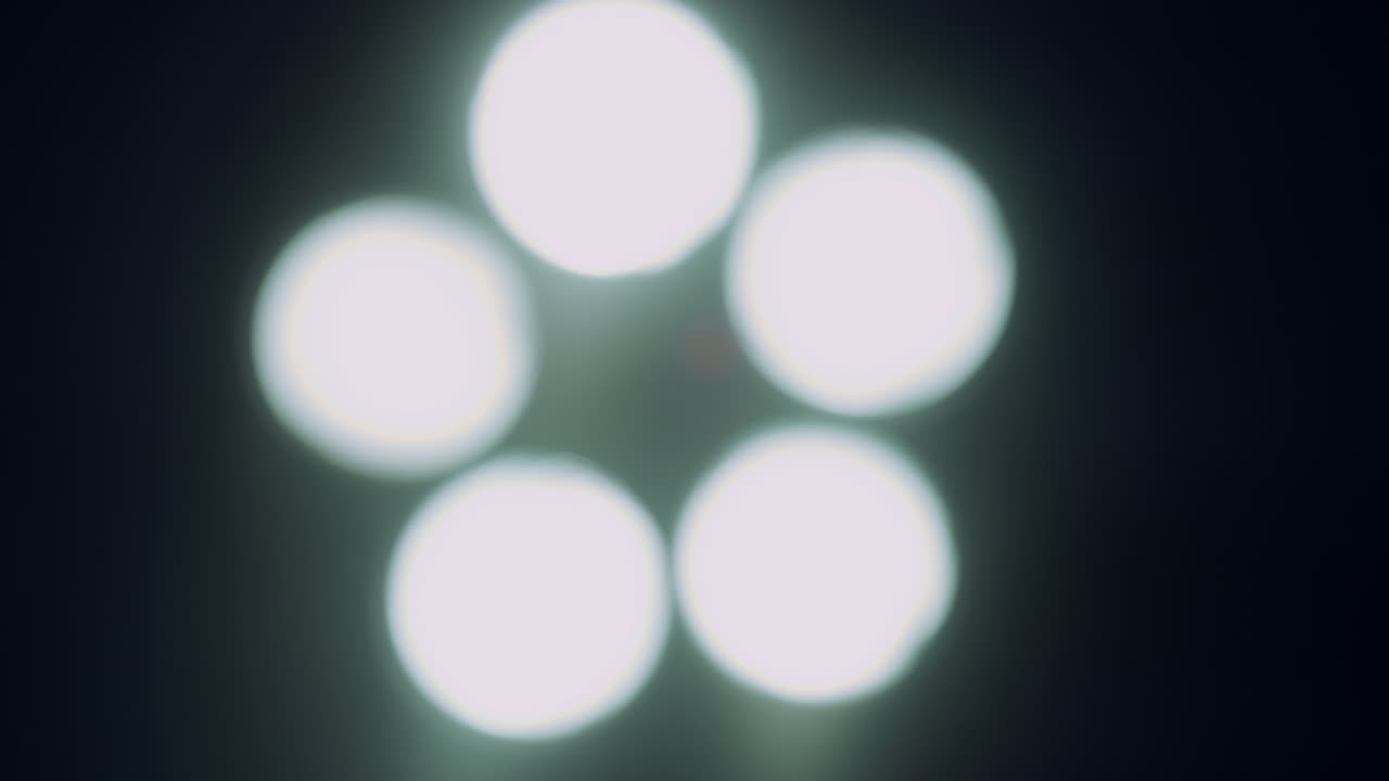 밝은 수술 램프가 어두운 병원 수술실에서 꺼지고 있습니다.