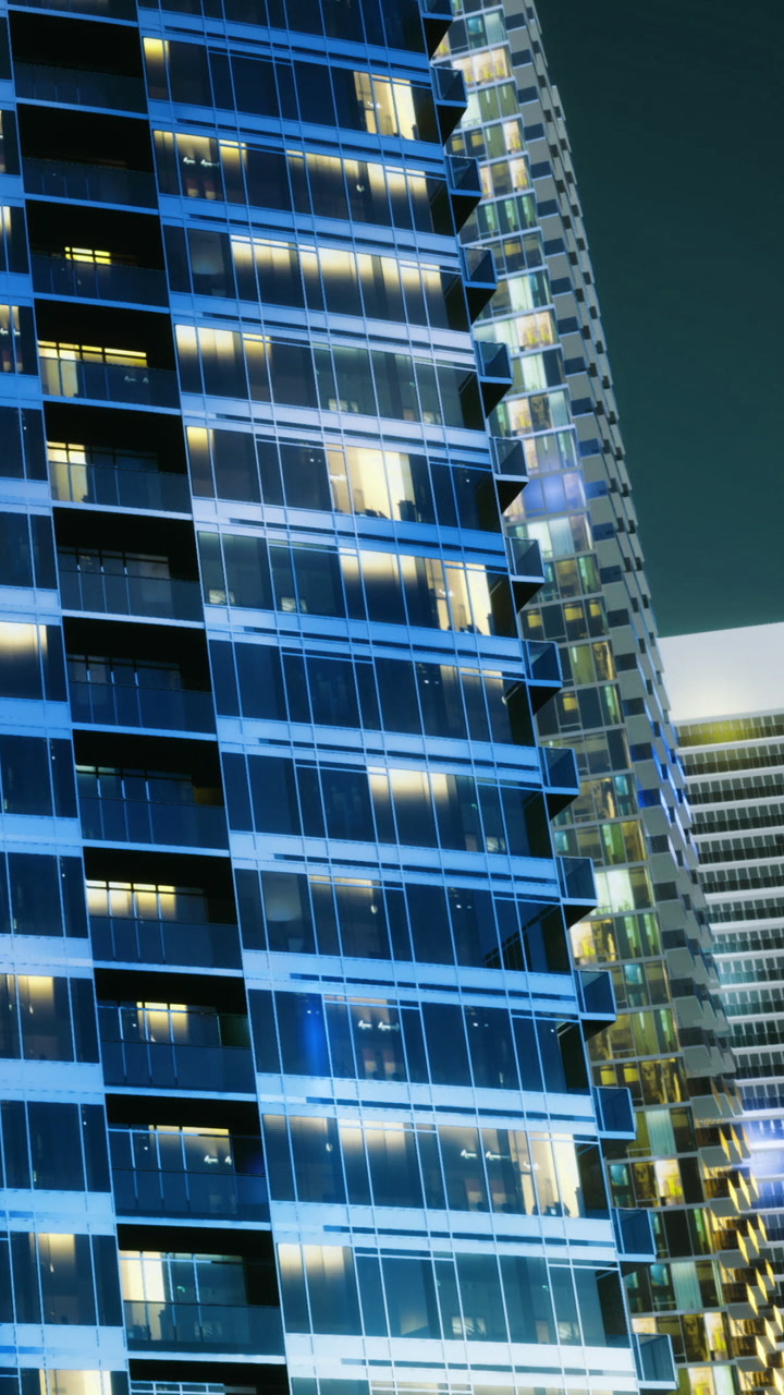 Office building at dusk with lights on in a cityscape setting