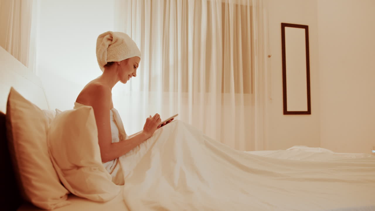 태블릿과 함께 침대에서 휴식을 취하는 여자