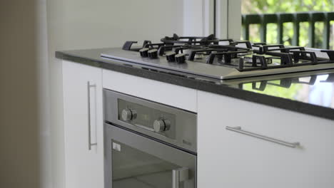 gas cook top and oven close up white kitchen cabinetry stone benchtop