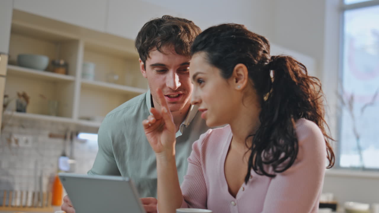 parejas felices desayunando tableta en la cocina de primer plano. pareja buscando computadora