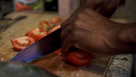 slicing tomatoes to add into meatball sauce preparing ingredients to make vegan beyond meatballs with spaghetti and meat sauce