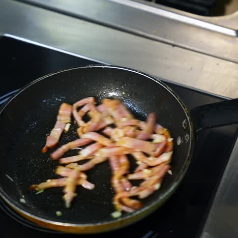 cooking bacon for breakfast. chef turns crispy bacon in frying pan. ingredients for burger. close up