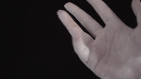 mujer joven pintada a mano con color blanco moviéndose suavemente en un fondo negro