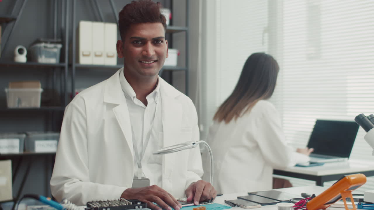 Portrait of Cheerful Repairman Examining Smartphone