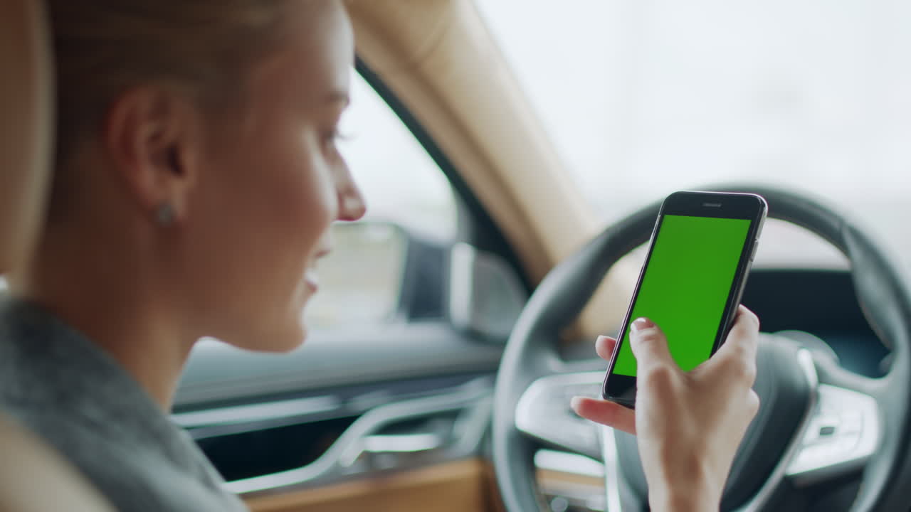 retrato de una mujer de negocios con un teléfono inteligente en el coche. mujer con un teléfono de pantalla verde