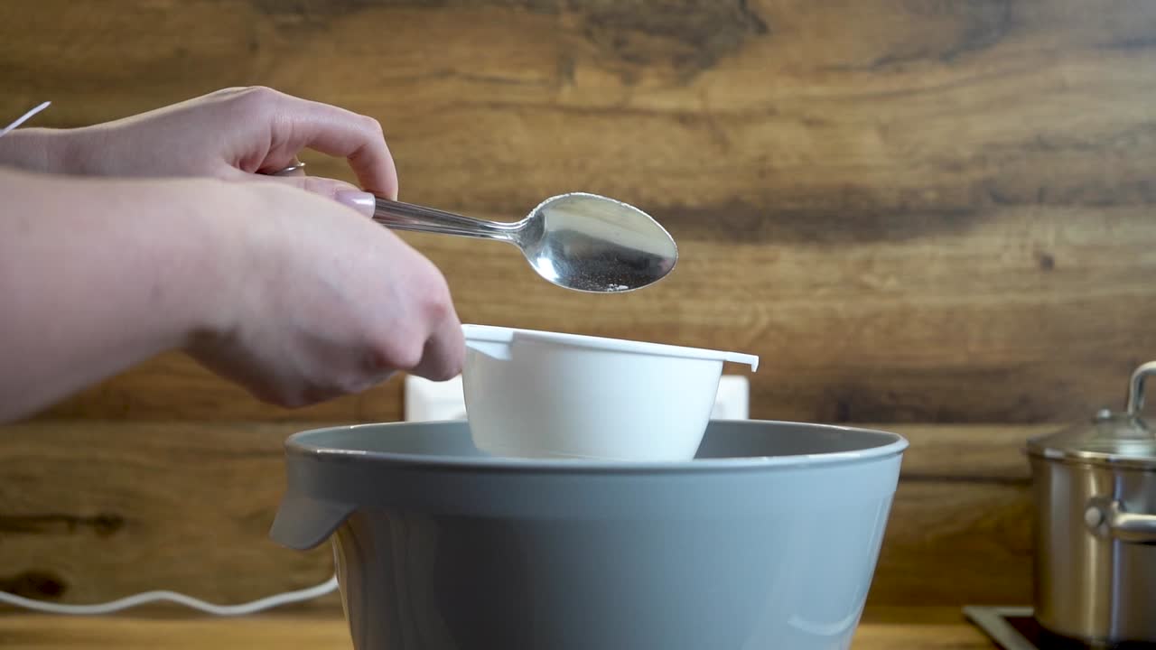 Woman Puts a Spoon of Flour into a sieve