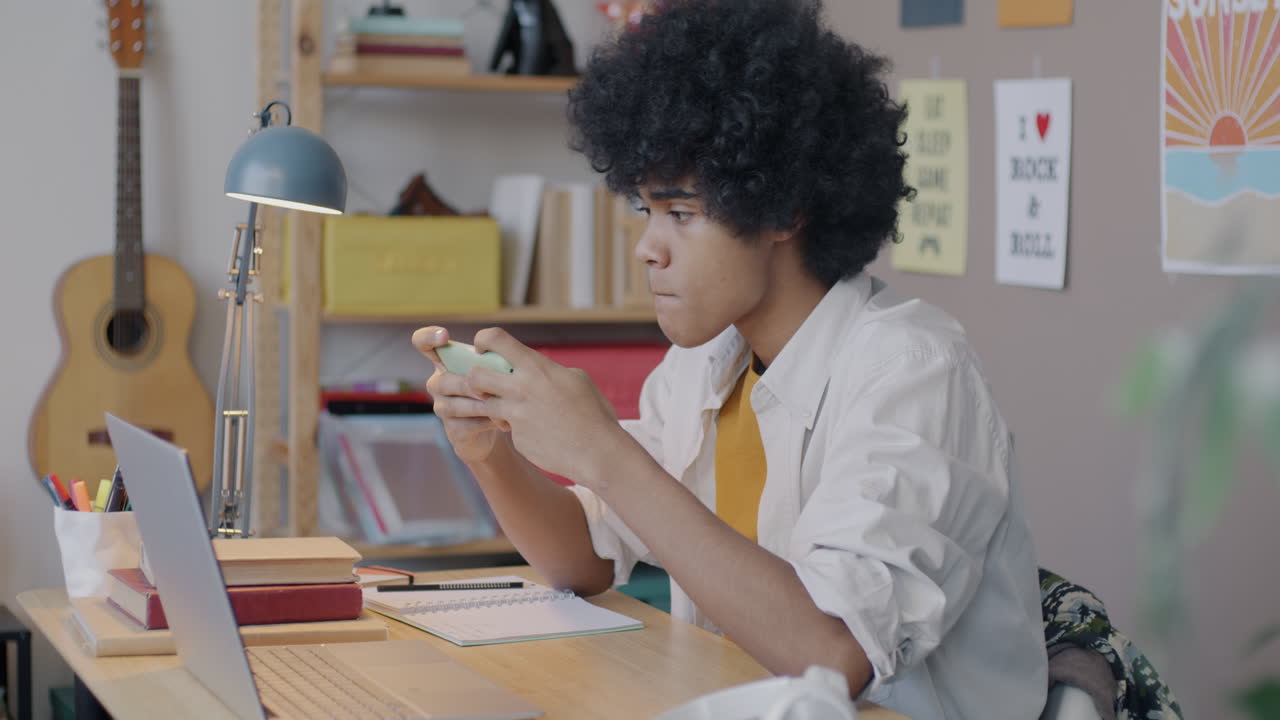 Teenager using smartphone at desk