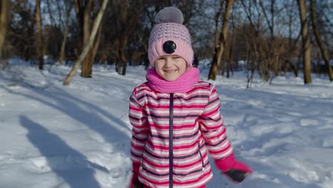 Smiling-child-kid-looking-at-camera,-embracing,-fooling-around,-hugging-in-winter-snowy-park-forest