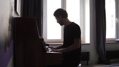 bearded man professionally play the piano at home