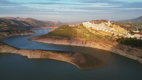 Iznajar-Weißes-Bergdorf-Und-Wasserreservoir-In-Andalusien,-Spanien---Luft-4k-Kreisen