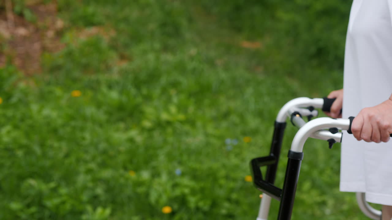 Eldre person går med rullator i en park
