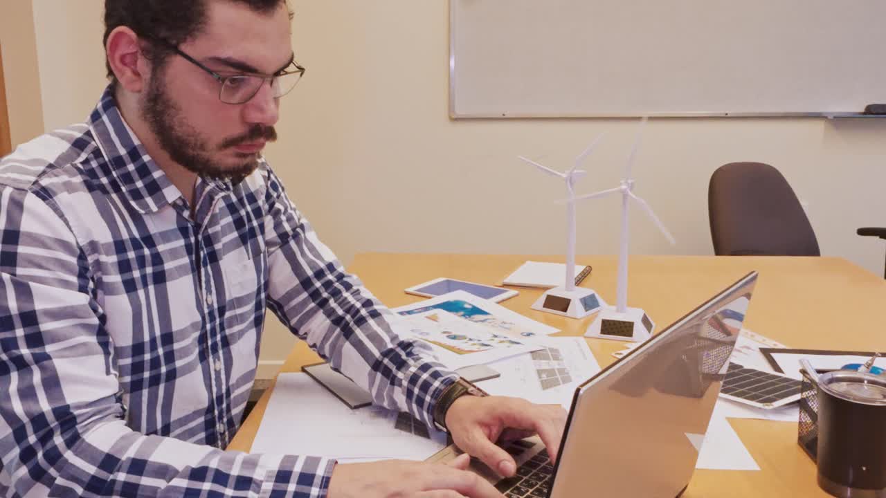 Young Businessman in Plaid Shirt Engaged in Computer Work