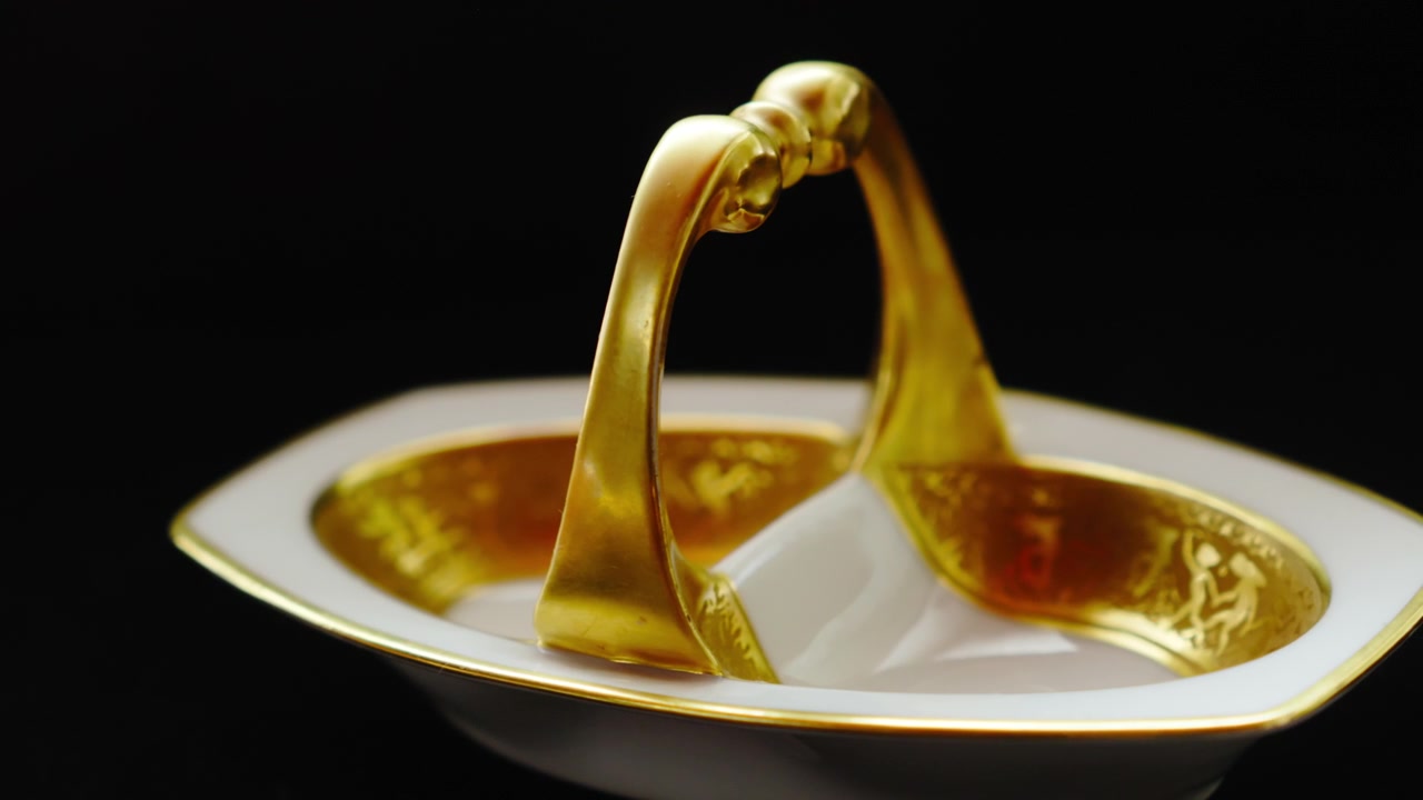 Lussuose stoviglie placcate oro isolate su uno sfondo nero, che simboleggiano ricchezza, status e gusto raffinato. Perfetto per pubblicità di prodotti premium, branding di lusso e storytelling visivo elegante