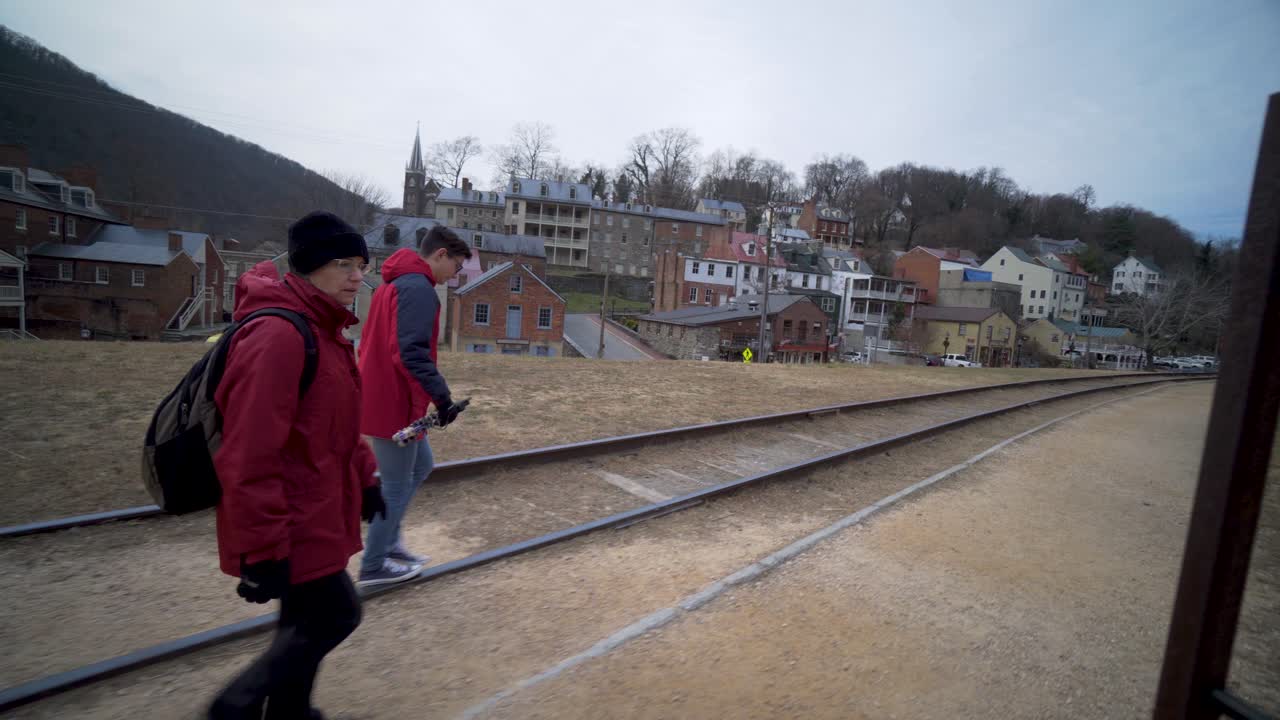 Mature woman and her teenage son walk along a berm talking and pointing to places in Harpers Ferry National Park in Harpers Ferry, WV.