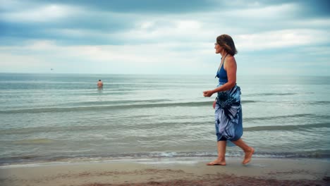 Mujer-Madura-Caminando-Por-La-Playa-Mirando-El-Mar-En-Karkle-Lituania---Plano-General