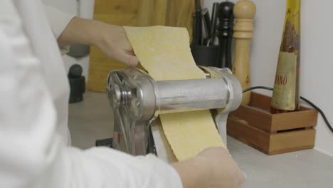 pasando masa de pasta a través de la máquina de prensa
