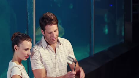 young-couple-taking-a-selfie-in-front-of-fish-tank-