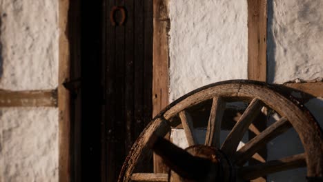 old wood wheel and black door at white house